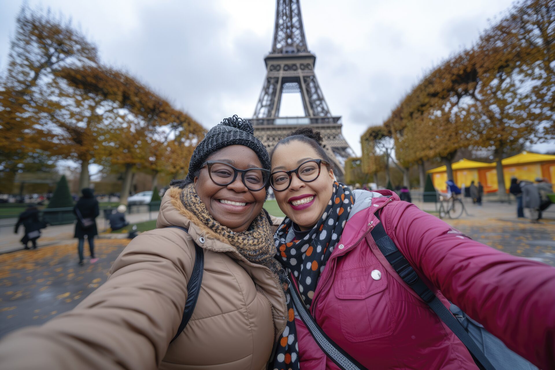Deux amies souriantes devant la Tour Eiffel à Paris